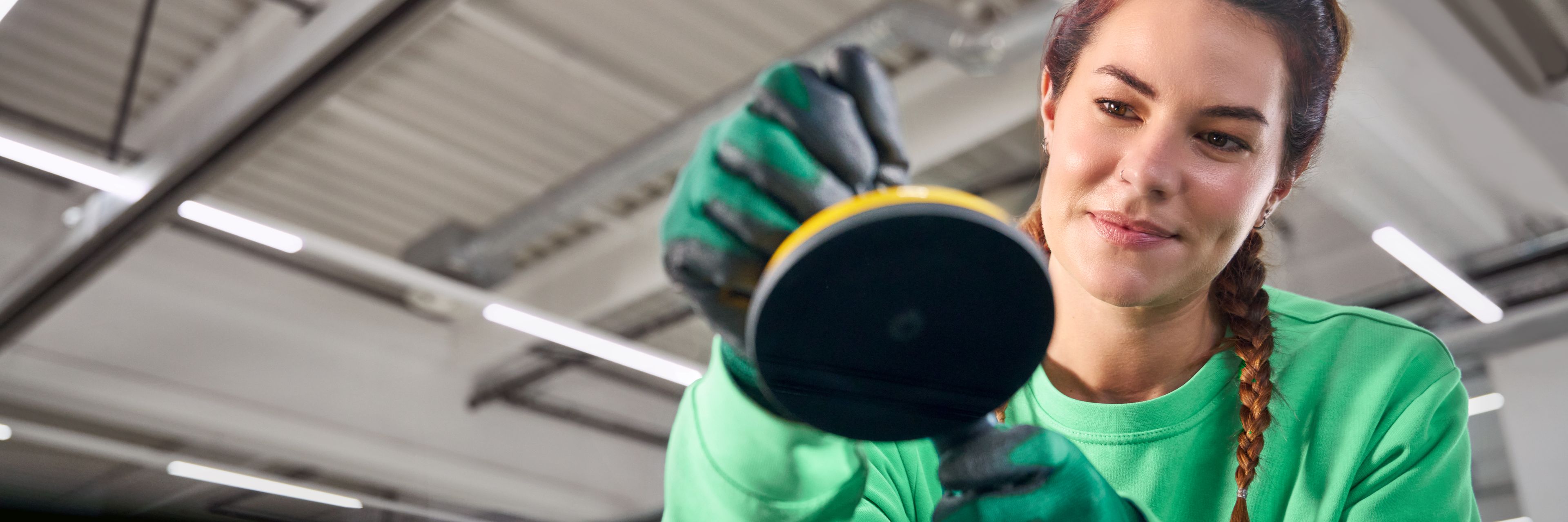 Serviserka preverja poškodbo vetrobranskega stekla na vozilu Škoda v servisni delavnici