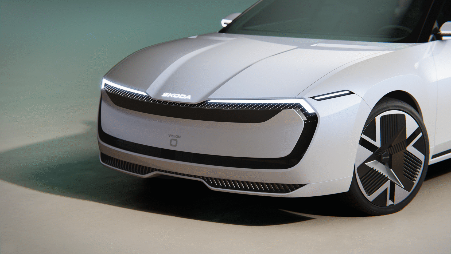 Na sliki je futuristični električni avtomobil znamke Škoda, model Vision O. Avtomobil ima aerodinamično obliko, LED žaromete in moderne platišča. Sprednji del vozila je zaprt, brez tradicionalne maske hladilnika.