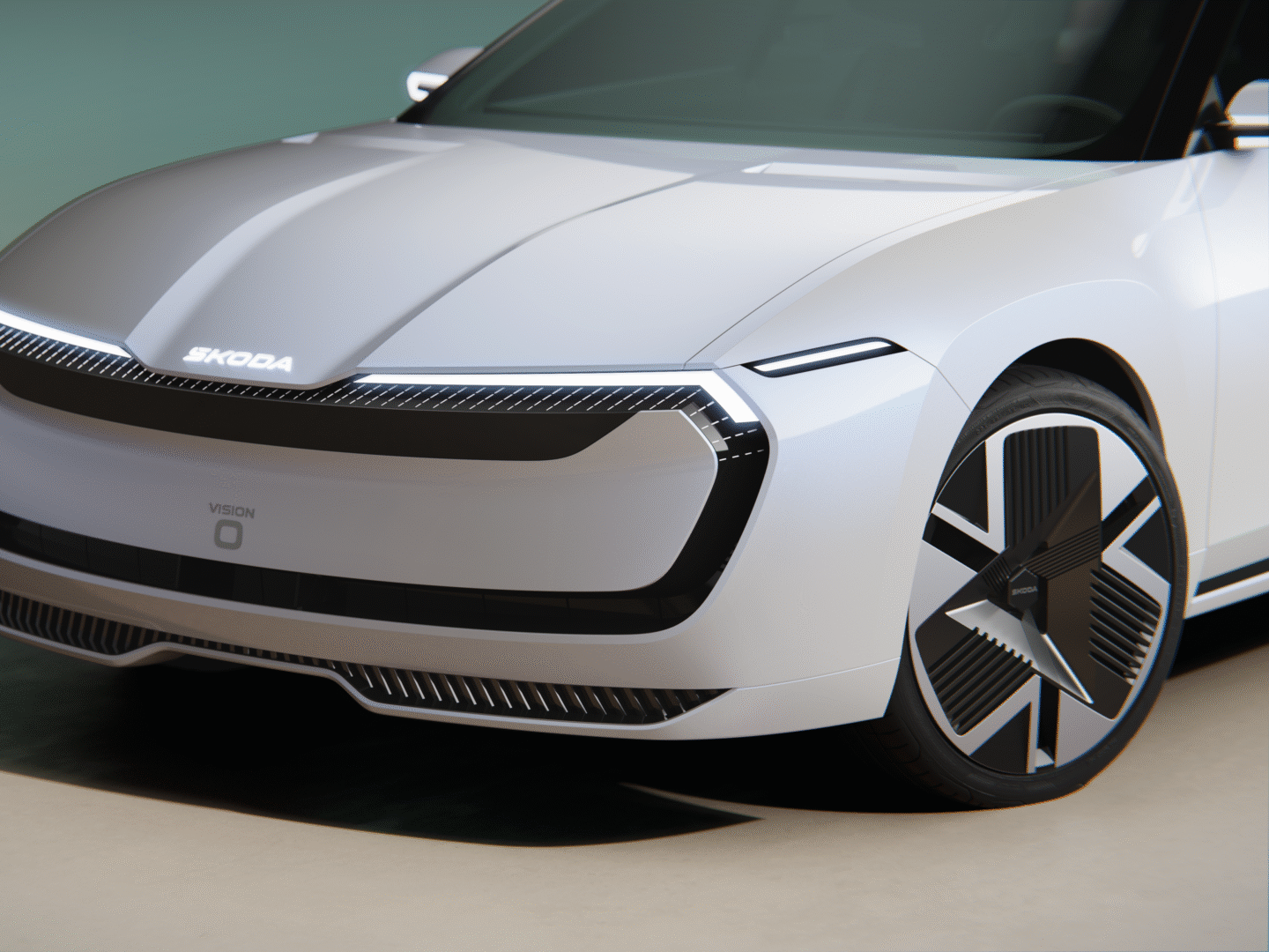 Na sliki je futuristični električni avtomobil znamke Škoda, model Vision O. Avtomobil ima aerodinamično obliko, LED žaromete in moderne platišča. Sprednji del vozila je zaprt, brez tradicionalne maske hladilnika.
