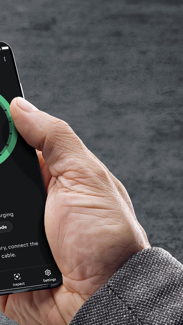 Stranka v roki drži mobitel na katerem je viden ekran s podatki o stopnji polnjena visokonapetostne baterije v vozilu Škoda