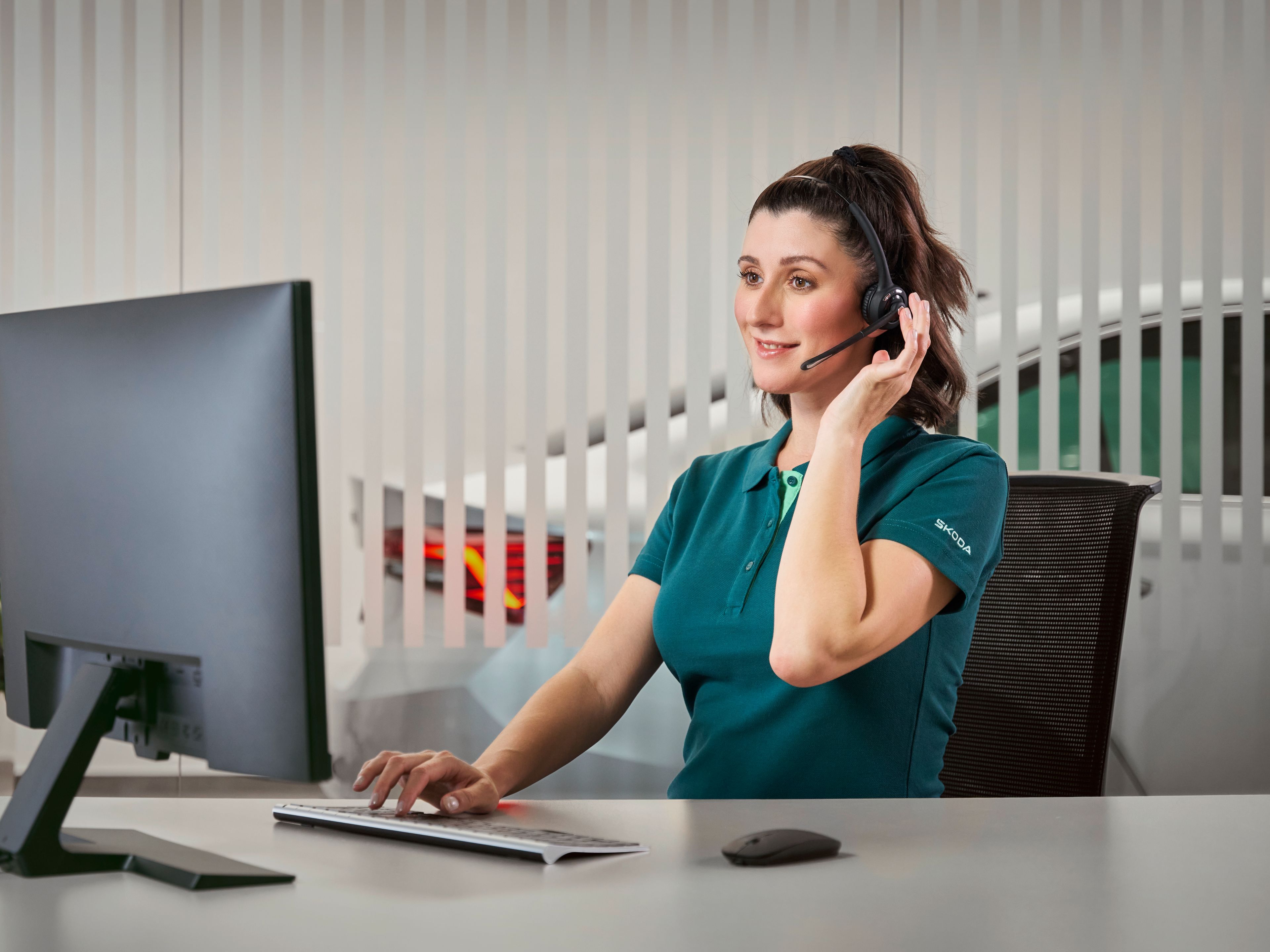 Gospa v klicnem centru Škoda govori s stranko po telefonu