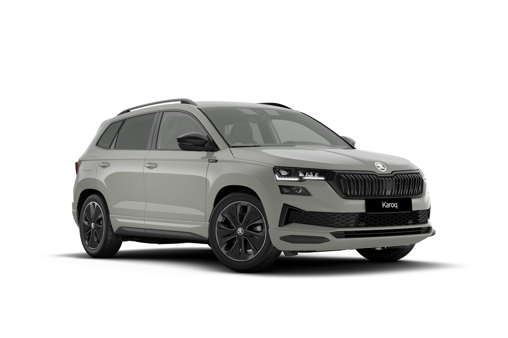 Slika prikazuje srebrno siv SUV vozilo znamke Škoda Karoq. Avto ima črne platišča, sprednje LED žaromete in modern oblikovan sprednji del. Karoserija vozila je kompaktna in elegantna.