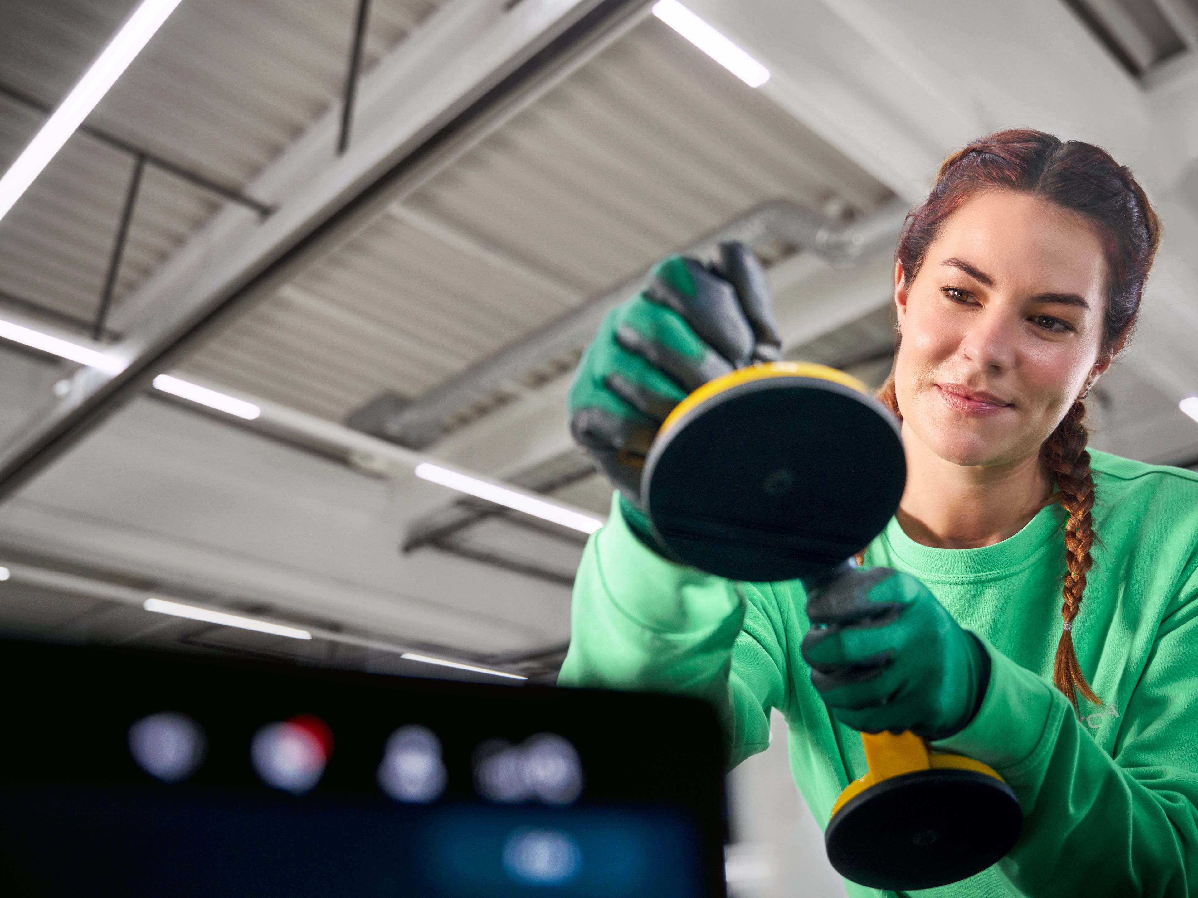 Serviserka preverja poškodbo vetrobranskega stekla na vozilu Škoda v servisni delavnici