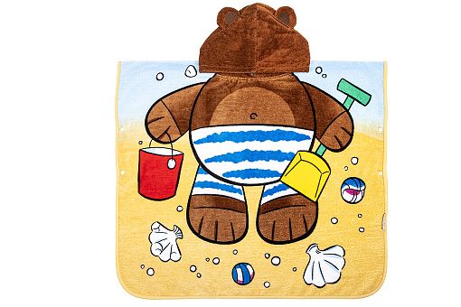 Otroška ilustracija medvedka na plaži, oblečenega v modro-bele črtaste kopalke. V eni roki drži rdečo kanglico, v drugi zeleno lopatko z rumeno zajemalko. Okoli njega so školjke, majhne žogice in ozadje peska z modrim nebom.