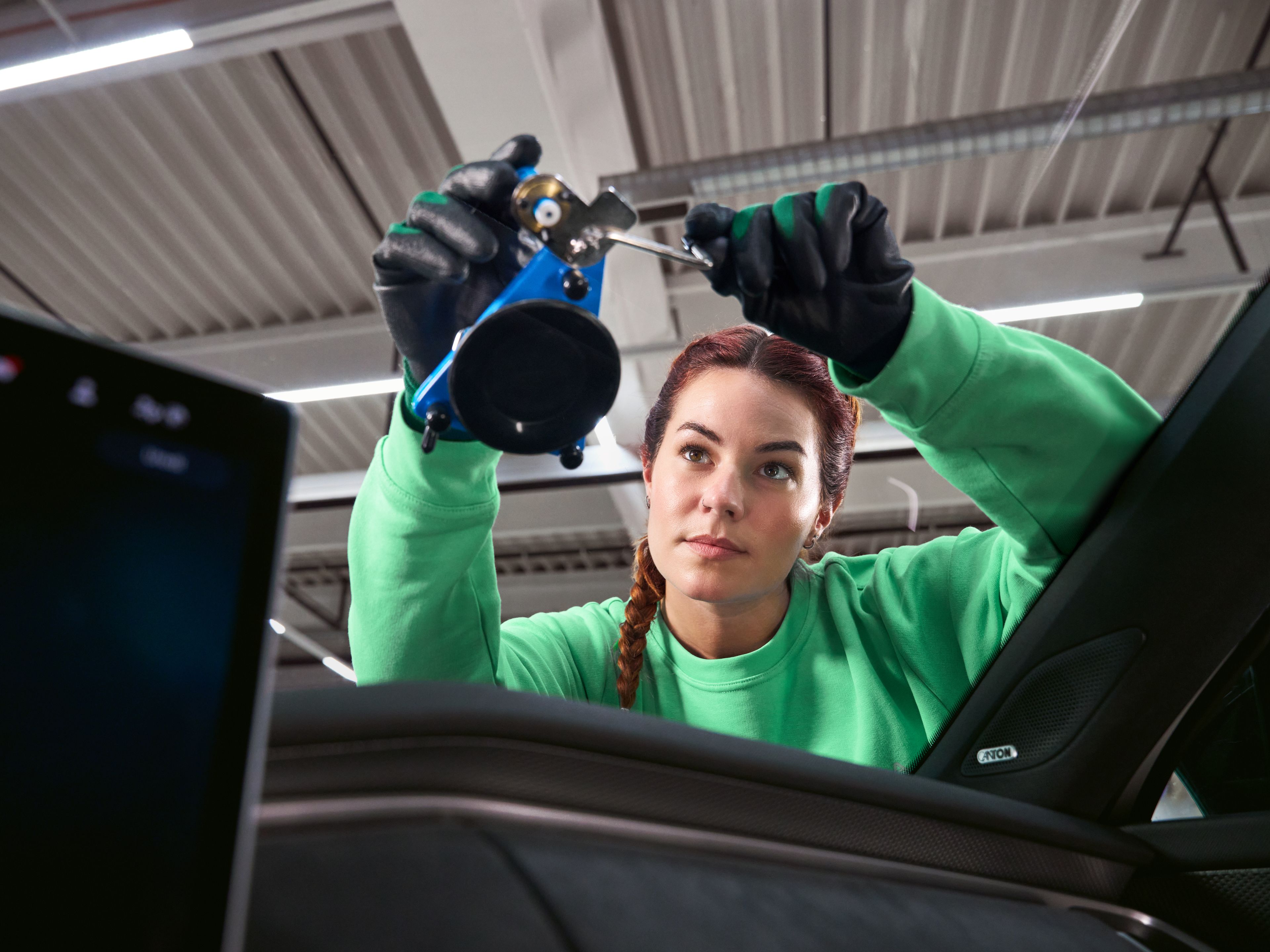 Serviserka popravlja poškodbo vetrobranskega stekla na vozilu Škoda v servisni delavnici