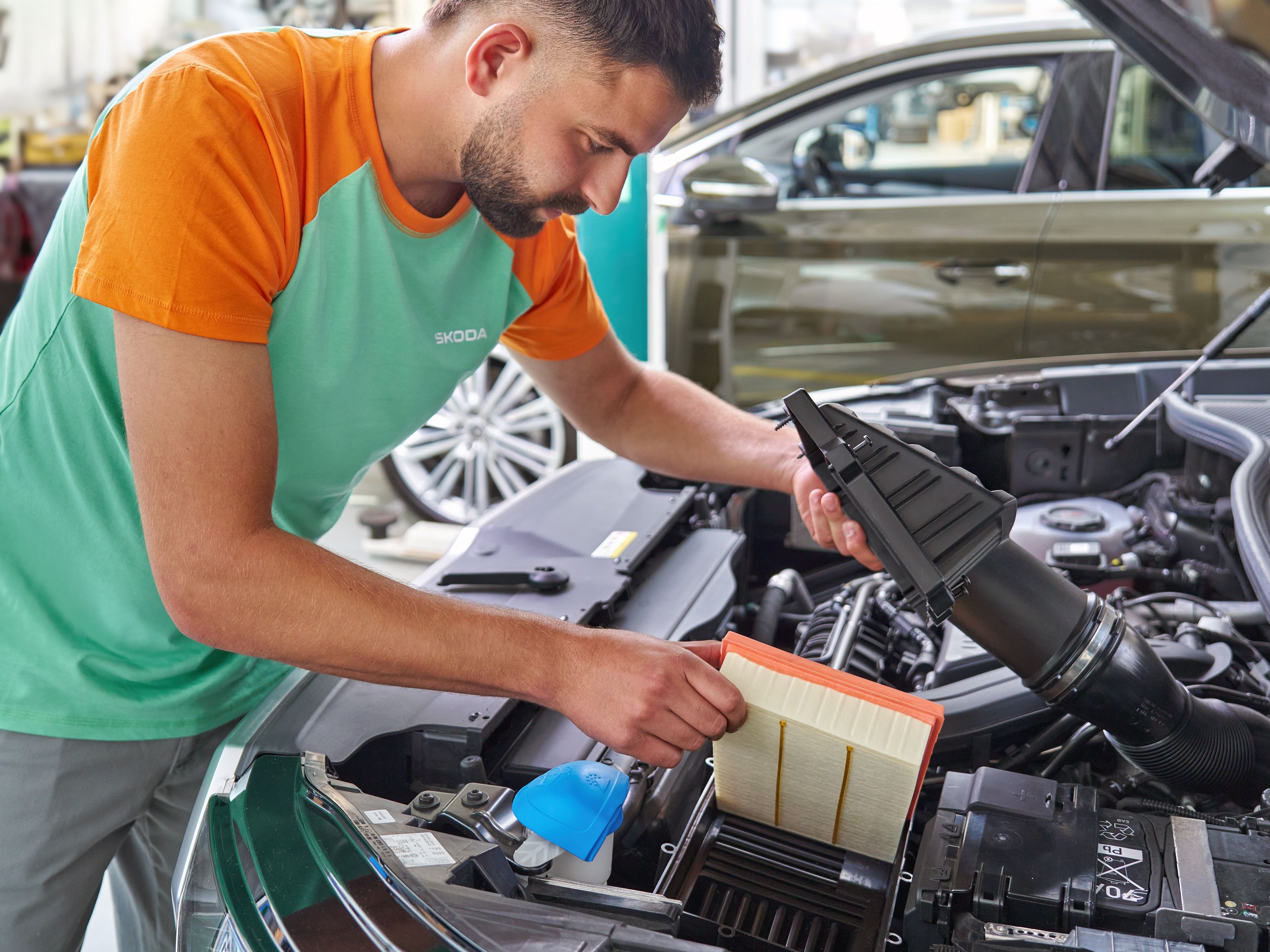 Serviser menja kabinski filter v vozilu v servisni delavnici Škoda