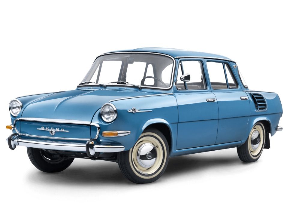 Modra klasična avtomobila Škoda z retro dizajnom, ki vključuje kromirane elemente na sprednjem delu. Vozilo ima štiri vrata in značilne okrogle žaromete. Pnevmatike so belo obrobljene.