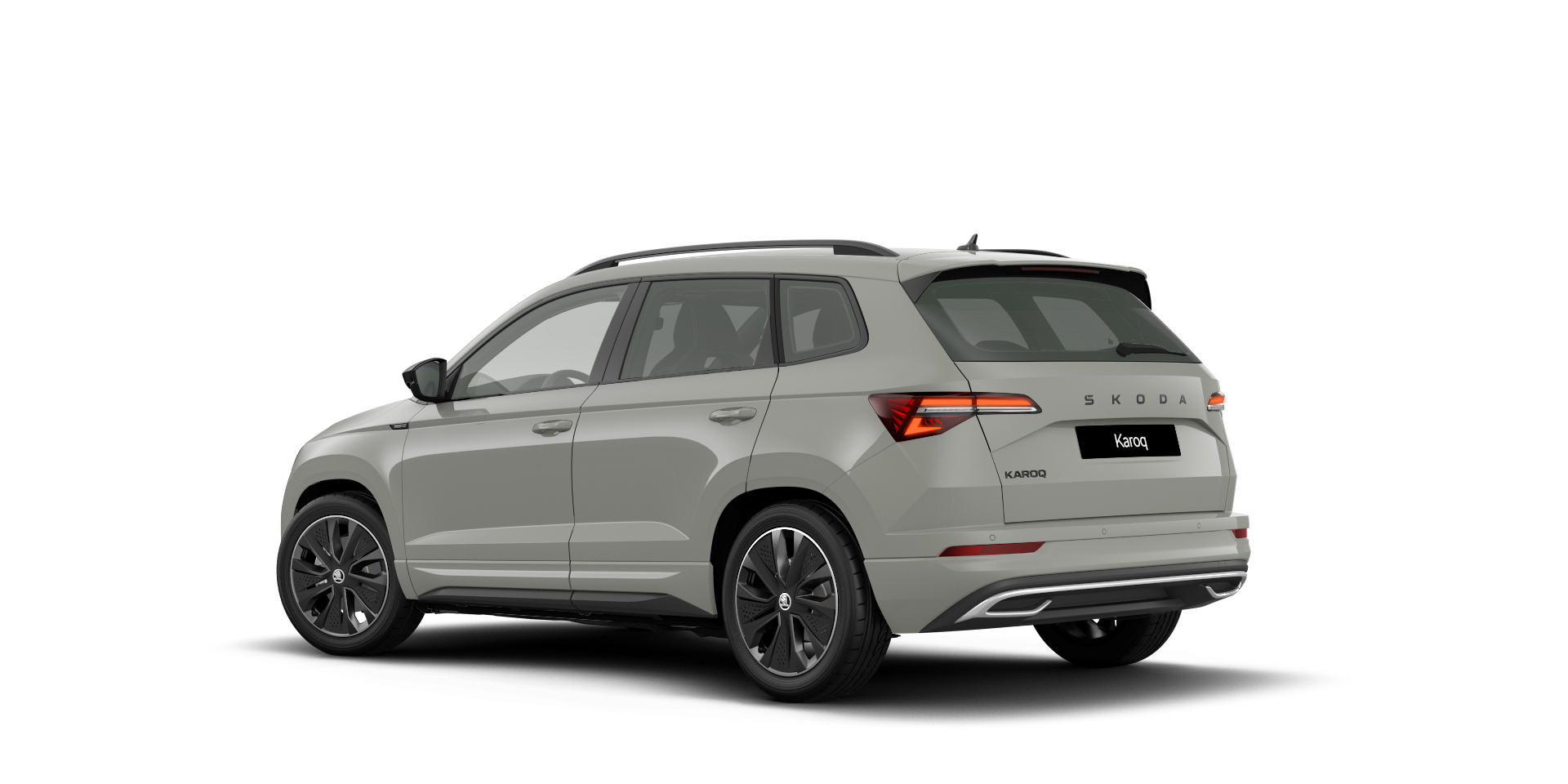 Siva Škoda Karoq je srednje velik SUV s sodobnim dizajnom. Ima elegantne linije in prostoren prtljažnik. Zadnja stran vozila vključuje LED luči in logotip znamke.
